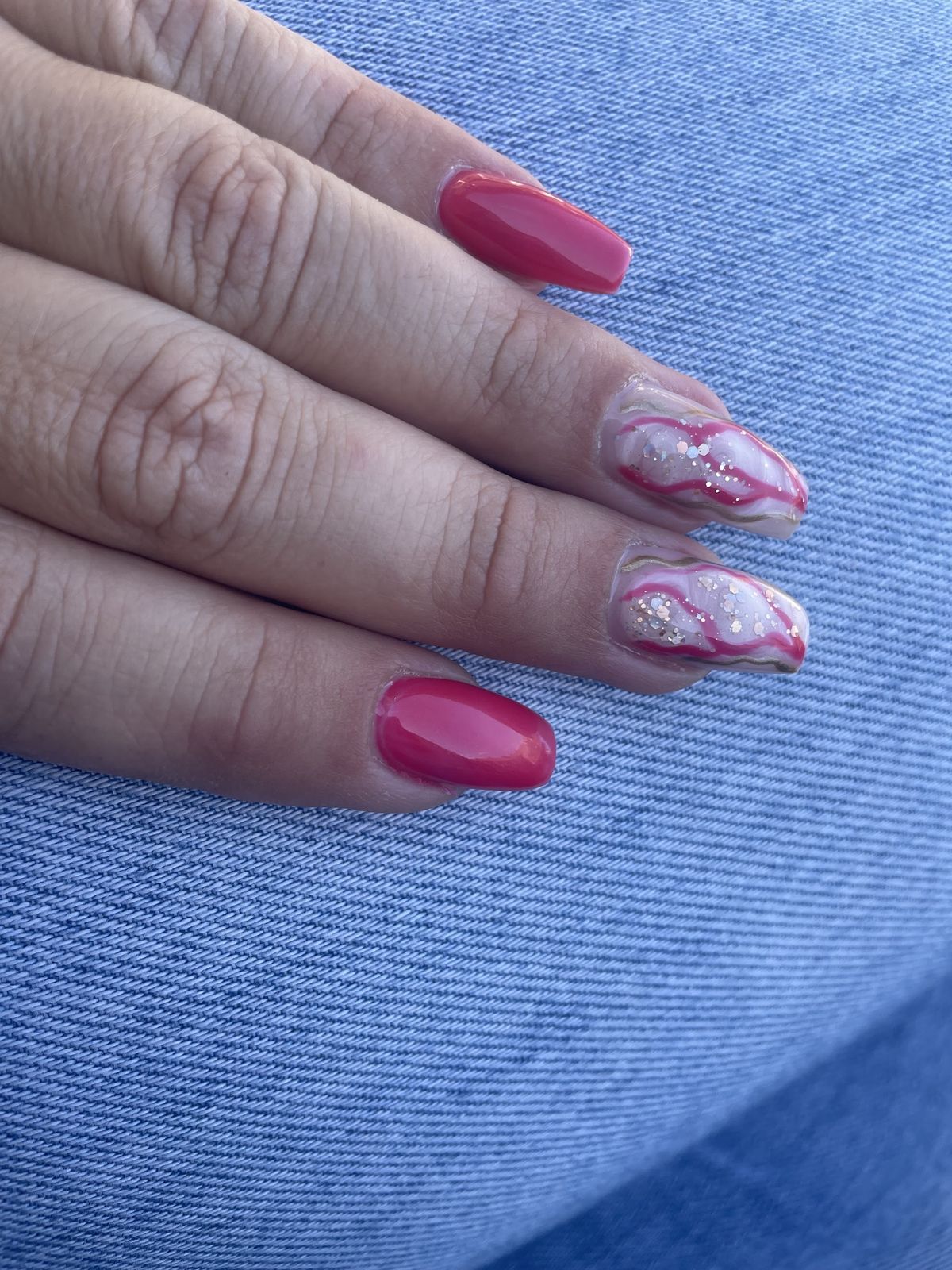 Korte nagels in frambozenroze met gemarmerde accentnagels